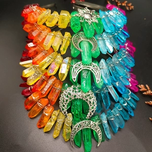 Detail of handmade rainbow crystal headbands with moon and sun charms on a dark surface