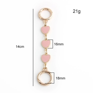 Detailed view of pink enamel heart bag charm with gold metal clasp measuring 14cm long