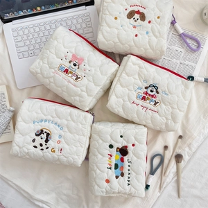 Detail of quilted cotton makeup bags with cute dog embroidery and zipper closure
