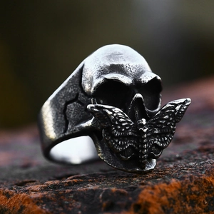 Vintage stainless steel moth skull ring with gothic antique silver finish on a rustic stone