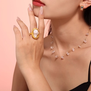 Ins style gold ring with irregular baroque pearl on pink background with model