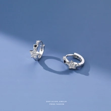 Macro view of S925 sterling silver star earrings with black enamel and pavé detail