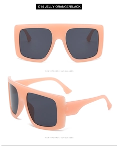 Detail view of oversized jelly orange square sunglasses with dark grey lenses and wide temples