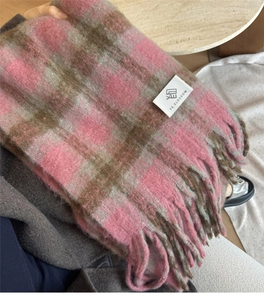 Close-up of pink and brown plaid cashmere scarf showing soft brushed texture and tassels