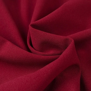 Detailed macro view of dark red chiffon fabric texture with elegant soft drapes