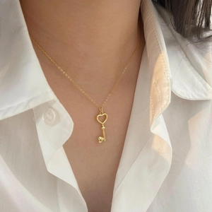 Elegant 925 sterling silver heart key necklace in gold finish worn by a model