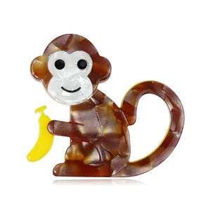 Handmade acrylic monkey brooch with brown marble texture and yellow banana detail