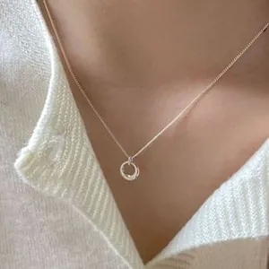 Detail of silver double interlocking circle necklace on model with knit sweater