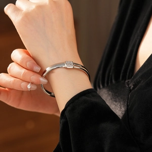 Gros plan d'un bracelet ouvert en acier titane argenté avec boucle en diamants