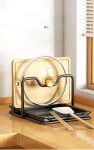 Detail of black metal pot lid rack with dual slots and removable drip tray on counter