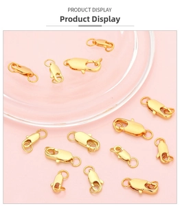 Nahaufnahme vergoldeter Karabinerverschlüsse für DIY-Schmuck auf rosa Hintergrund