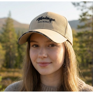 Outdoor close-up of beige cotton baseball cap with Vintage YOURSELF embroidery and long brim