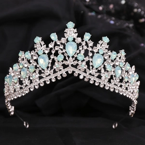 Close-up of Baroque silver bridal crown with blue gemstones on black velvet background