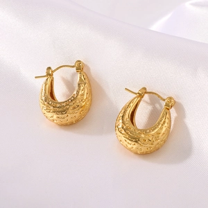 U-shaped hollow gold stainless steel earrings with hammer texture on white silk fabric