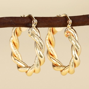 Schicke goldene Creolen mit gedrehter Form und polierter matter Textur für Damen