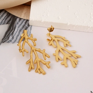 Polished 18K gold plated stainless steel coral branch earrings on textured stone