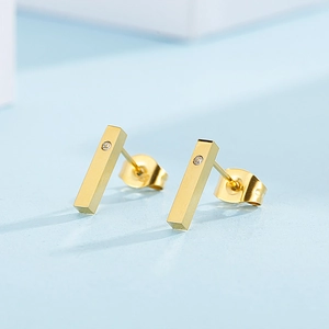 Macro shot of gold vertical bar earrings with inlaid diamonds and matching backings