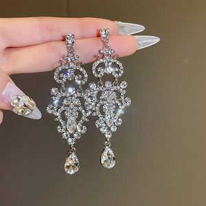 Macro shot of silver drop earrings with intricate crystal setting and teardrop pendant