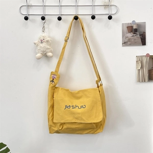 Detail of yellow canvas messenger bag with Jia shijiu blue embroidery and balloon accents