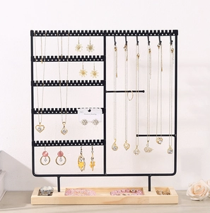 Detail view of multi-layer black metal jewelry stand with solid wood base for storage