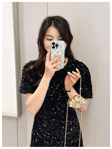 Detailed view of a gold shell-shaped mini metal crossbody bag with a delicate chain