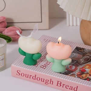 Detailed view of pink and white tulip shaped scented candles on a decorative book