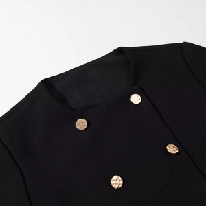 Dettaglio blazer nero girocollo con bottoni dorati martellati e trama di tessuto