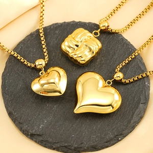 Colliers élégants en acier titane doré avec pendentifs cœur et carrés sur pierre noire