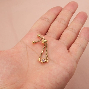 Adjustable gold ring with pink gemstone slider, minimalist stainless steel jewelry design