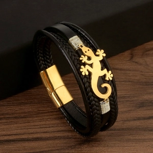 Close-up of black lizard leather braided bracelet with gold lizard charm and magnetic clasp