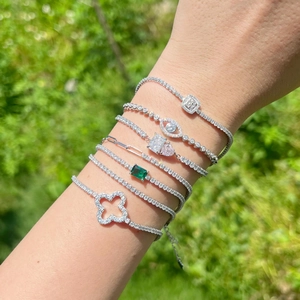 Elegant S925 sterling silver four-leaf clover tennis bracelets stacked on a woman's wrist