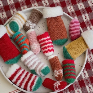 Close-up of colorful knitted mini socks with white plush trim and varied textures
