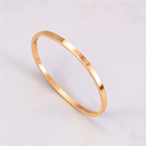 Detail of rose gold titanium steel bangle showing polished mirror finish and secure hinge