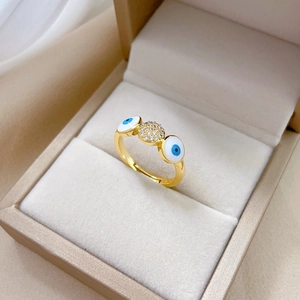 Gold evil eye ring with blue zircon stones displayed in a luxury jewelry box