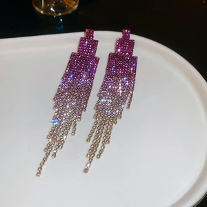 Macro shot of gradient purple rhinestone tassel earrings with a shimmering silver finish