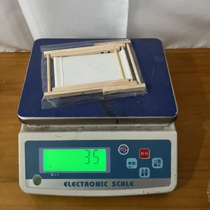 Miniature wooden easel and canvas weighing 35g on an electronic scale for weight demo