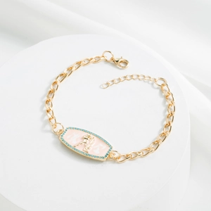 Detail of 18K gold plated bracelet featuring a pink enamel Aquarius zodiac pendant and gems