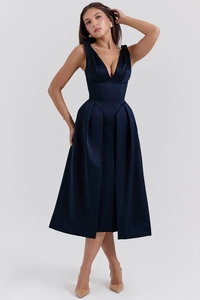 Détail du tissu en satin bleu marine élégant et du col en V sur cette robe longue d'été cintrée