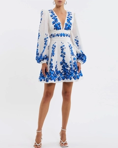 Detail of white deep V-neck mini dress with blue floral embroidery and lantern sleeves