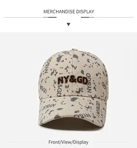 Vue de face d'une casquette de baseball beige avec broderie NY&GD et taches