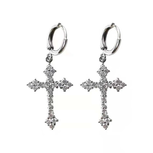 Close-up of silver cross drop earrings with sparkling rhinestone pavé setting