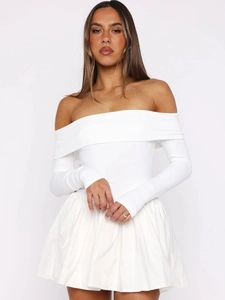 Détail d'un haut blanc à épaules dénudées à manches longues et mini-jupe plissée assortie