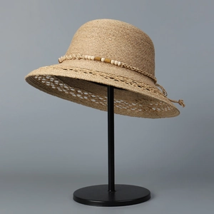 Detailaufnahme der Raffia-Sonnenhut-Webung mit Perlendekoration und floralem Randmuster