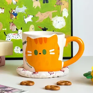 Detail of cute orange lucky kitten ceramic mug with MEOW text and thick orange handle