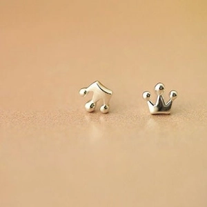 Polished silver geometric crown stud earrings for women on a beige minimalist background