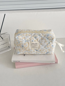 Détail de la trousse de toilette en velours côtelé fleuri jaune avec ruban et surpiqûres