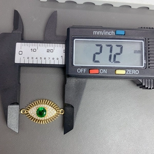Detailed measurement of 27.2 mm gold Evil Eye connector with green gemstone and zircons