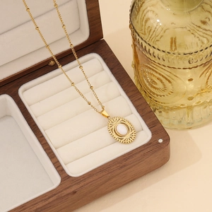 Detailed close-up of a vintage gold oval natural stone necklace on a velvet wooden case