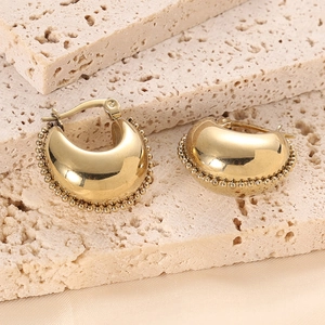 Detailed macro view of 14K gold plated C-shaped earrings with decorative beaded edges