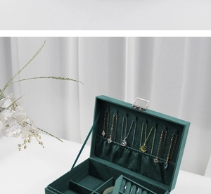 Three-layer green velvet jewelry box with metal lock showing necklace hooks and ring slots